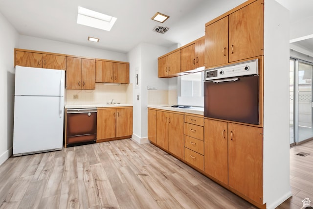 3616 S 860 E Unit 72, Salt Lake City, UT 84106 - kitchen with freestanding refrigerator, wall oven, dishwashing machine, a skylight, and light wood finished floors