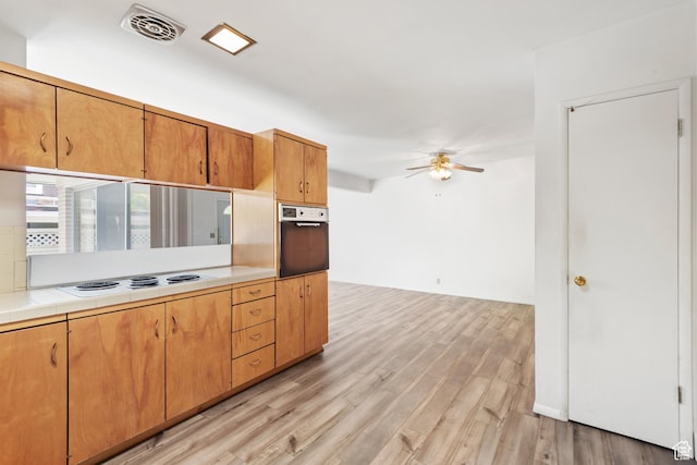 3616 S 860 E Unit 72, Salt Lake City, UT 84106 - kitchen featuring wall oven, white electric stovetop, light wood-type flooring, ceiling fan, and tile countertops