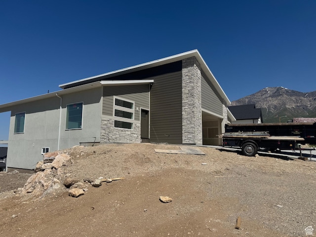 3023 N Mountain Rd E Unit 212, North Ogden, UT 84414 - view of property exterior featuring stone siding, a mountain view, and a garage