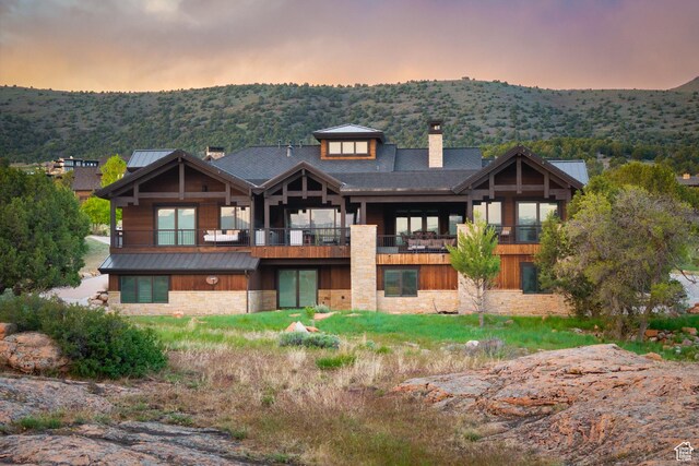 523 N Red Ct, Heber City, UT 84032 - back of property at dusk featuring a chimney, stone siding, a standing seam roof, and metal roof
