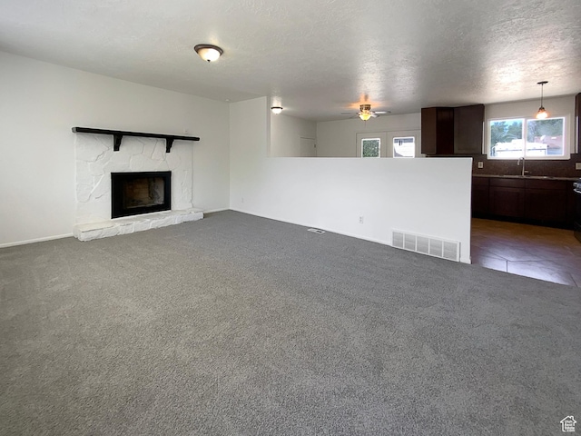 5644 S Treebeard Rd, Taylorsville, UT 84129 - unfurnished living room with a sink, ceiling fan, a fireplace, carpet, and baseboards
