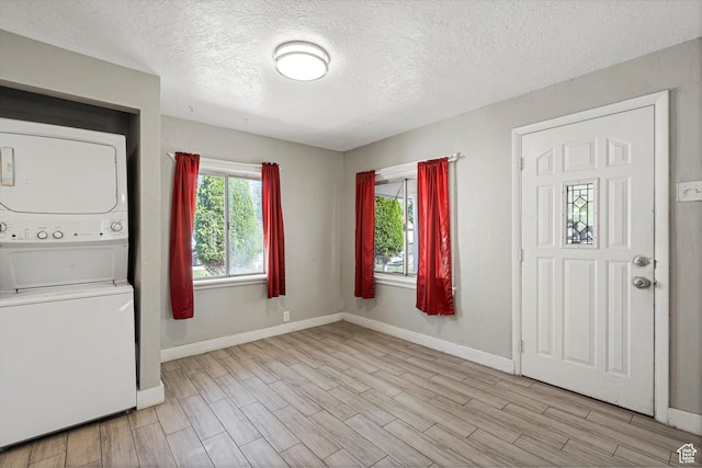 254 Franklin St, Ogden, UT 84401 - foyer with estacked washer and dryer, a textured ceiling, light wood finished floors, and baseboards