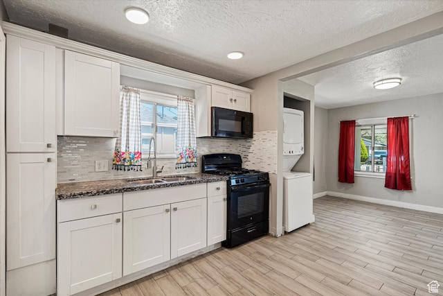 254 Franklin St, Ogden, UT 84401 - kitchen with black appliances, stacked washing machine and dryer, a sink, tasteful backsplash, and healthy amount of natural light
