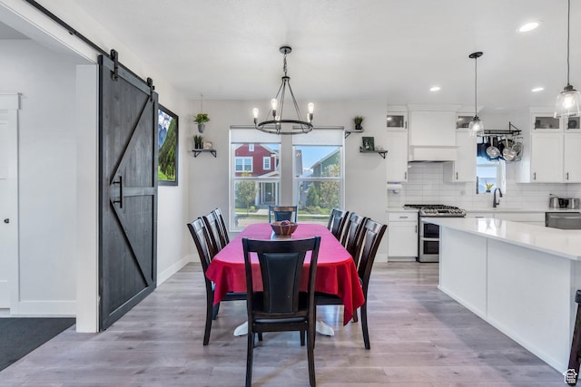 6228 W Copperhawk Dr S, South Jordan, UT 84009 - dining room featuring a barn door, a chandelier, light wood-style floors, recessed lighting, and baseboards