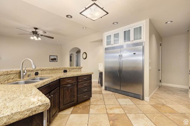 822 E Birken St, Washington, UT 84780 - kitchen with built in fridge, arched walkways, a sink, ceiling fan, and dark brown cabinetry