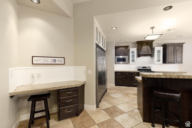 822 E Birken St, Washington, UT 84780 - kitchen with built in appliances, premium range hood, a breakfast bar area, dark brown cabinetry, and light stone countertops
