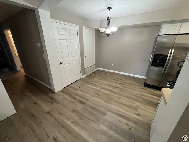 3478 E Rdg Route Rd Unit C1, Eagle Mountain, UT 84005 - unfurnished dining area with light wood-type flooring, baseboards, and a chandelier