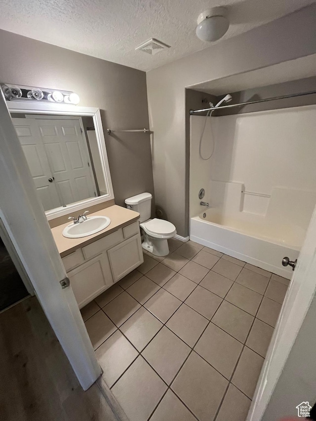 3478 E Rdg Route Rd Unit C1, Eagle Mountain, UT 84005 - full bathroom with toilet, vanity, washtub / shower combination, tile patterned floors, and a textured ceiling