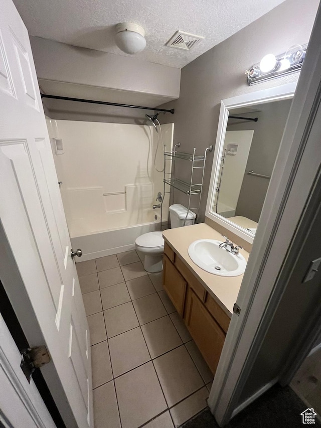 3478 E Rdg Route Rd Unit C1, Eagle Mountain, UT 84005 - full bathroom with tile patterned floors, toilet, vanity, shower / washtub combination, and a textured ceiling