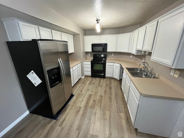 3478 E Rdg Route Rd Unit C1, Eagle Mountain, UT 84005 - kitchen with black appliances, a sink, light wood-type flooring, light countertops, and white cabinetry