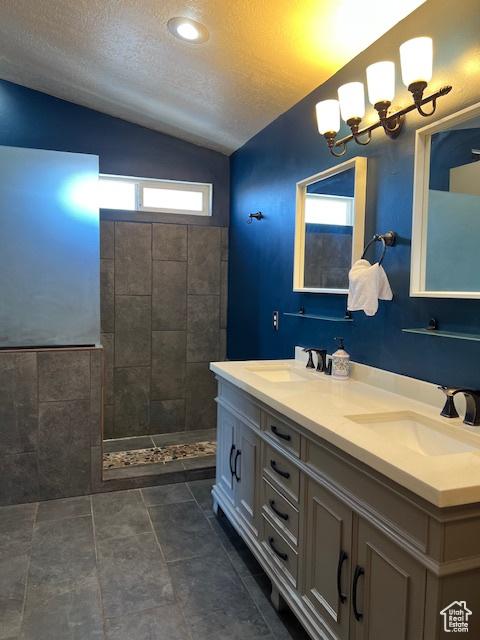 438 E Parowan Way, Draper, UT 84020 - full bathroom with lofted ceiling, double vanity, a textured ceiling, walk in shower, and a chandelier