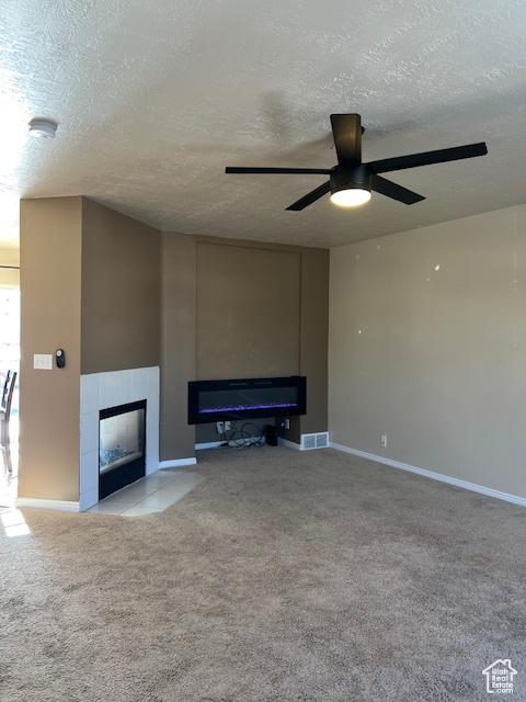 438 E Parowan Way, Draper, UT 84020 - unfurnished living room featuring a tile fireplace, a textured ceiling, ceiling fan, carpet, and baseboards