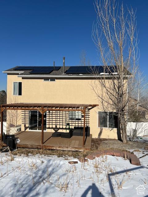 438 E Parowan Way, Draper, UT 84020 - snow covered back of property featuring stucco siding, solar panels, and a pergola