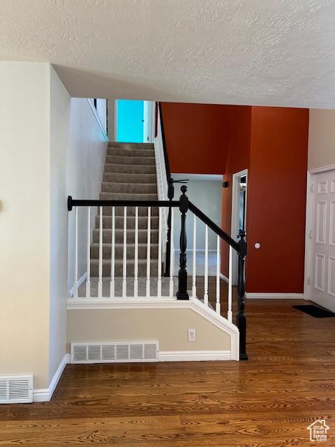 438 E Parowan Way, Draper, UT 84020 - staircase featuring a textured ceiling, wood finished floors, and baseboards