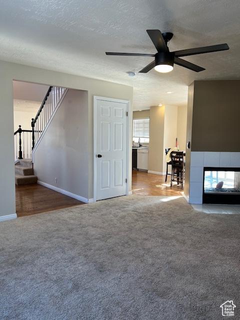 438 E Parowan Way, Draper, UT 84020 - unfurnished living room featuring carpet, a ceiling fan, baseboards, a tile fireplace, and a textured ceiling