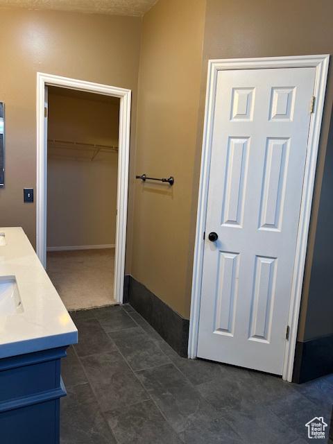 438 E Parowan Way, Draper, UT 84020 - bathroom with double vanity, a spacious closet, and baseboards
