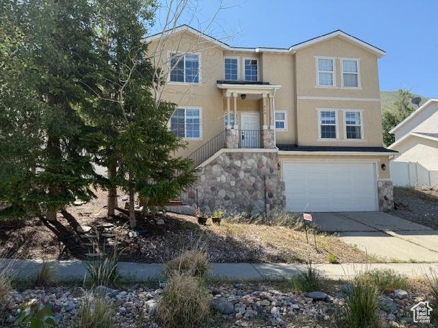 438 E Parowan Way, Draper, UT 84020 - view of front of property with driveway, an attached garage, stone siding, and stucco siding