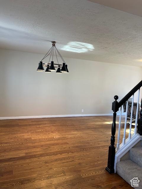 438 E Parowan Way, Draper, UT 84020 - staircase with wood finished floors, a chandelier, baseboards, and a textured ceiling