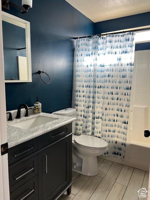 438 E Parowan Way, Draper, UT 84020 - full bath with vanity, toilet, shower / tub combo with curtain, wood tiled floors, and a textured ceiling