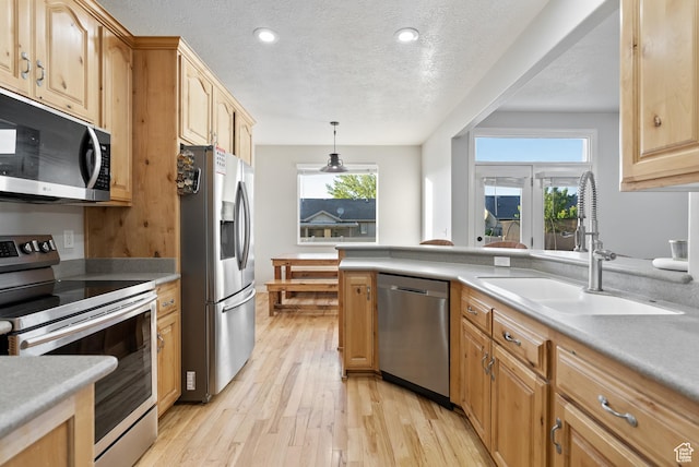 2047 E 1850 S, Spanish Fork, UT 84660 - kitchen with stainless steel appliances, a sink, light wood-style flooring, a textured ceiling, and light countertops