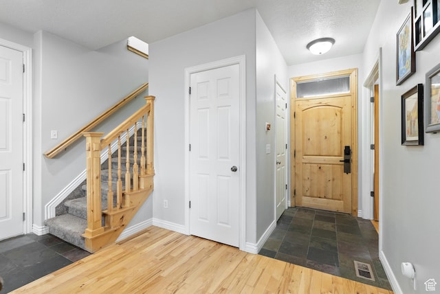2047 E 1850 S, Spanish Fork, UT 84660 - foyer featuring stairs, baseboards, a textured ceiling, and wood finished floors
