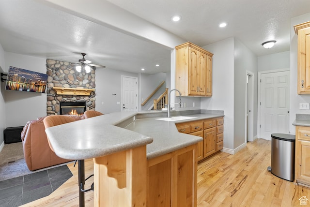 2047 E 1850 S, Spanish Fork, UT 84660 - kitchen with a sink, ceiling fan, a peninsula, a stone fireplace, and a kitchen breakfast bar