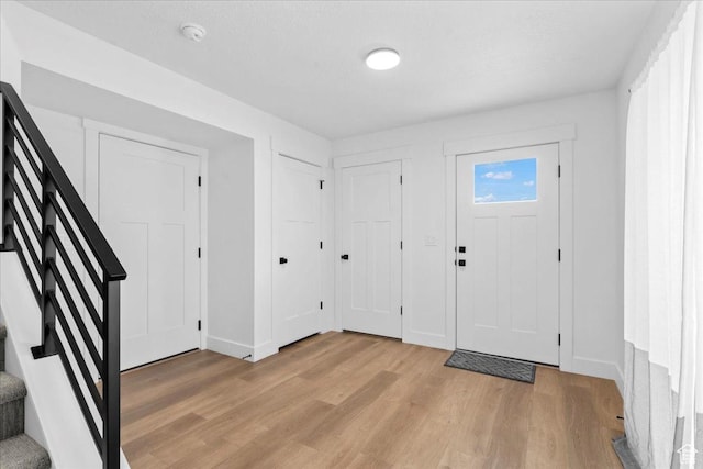 3466 S Peebles Ct E, South Salt Lake, UT 84115 - entrance foyer featuring light wood-style flooring, baseboards, and stairway
