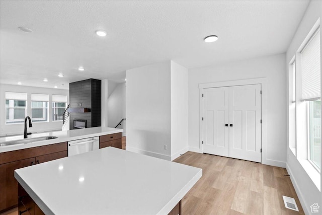 3466 S Peebles Ct E, South Salt Lake, UT 84115 - kitchen with a sink, stainless steel dishwasher, light wood-type flooring, light countertops, and recessed lighting