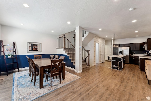 3880 S 1580 W Unit 224, West Valley City, UT 84119 - dining area featuring stairs, baseboards, light wood finished floors, recessed lighting, and a textured ceiling