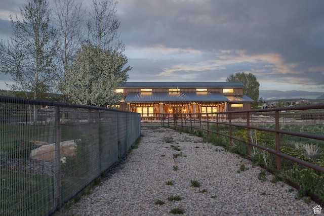 7778 N Greenfield Dr, Park City, UT 84098 - back of house at dusk with an exterior structure, an outdoor structure, and metal roof