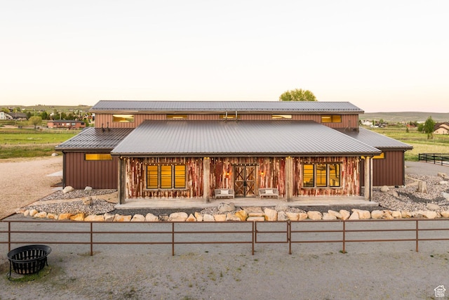7778 N Greenfield Dr, Park City, UT 84098 - back of property at dusk featuring board and batten siding, metal roof, and covered porch