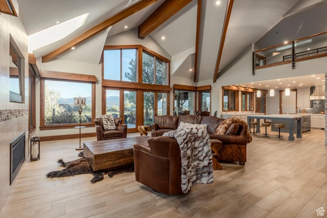 7778 N Greenfield Dr, Park City, UT 84098 - living area featuring beamed ceiling, light wood-type flooring, high vaulted ceiling, and a glass covered fireplace