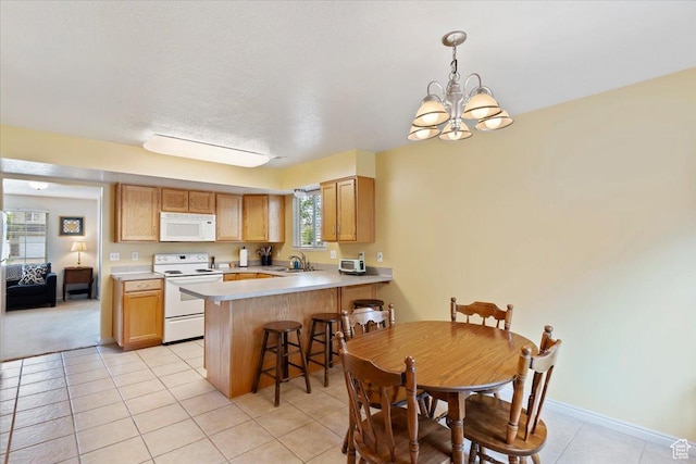 1338 E 6125 S, South Ogden, UT 84405 - kitchen with white appliances, a chandelier, a peninsula, light countertops, and light tile patterned floors
