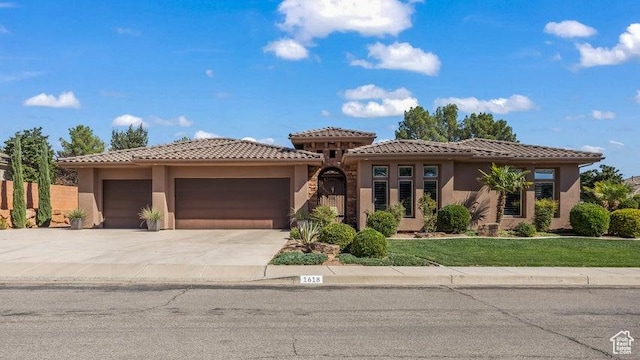1618 N 775 W, Washington, UT 84780 - view of front of house featuring an attached garage, driveway, stucco siding, a tile roof, and a front lawn