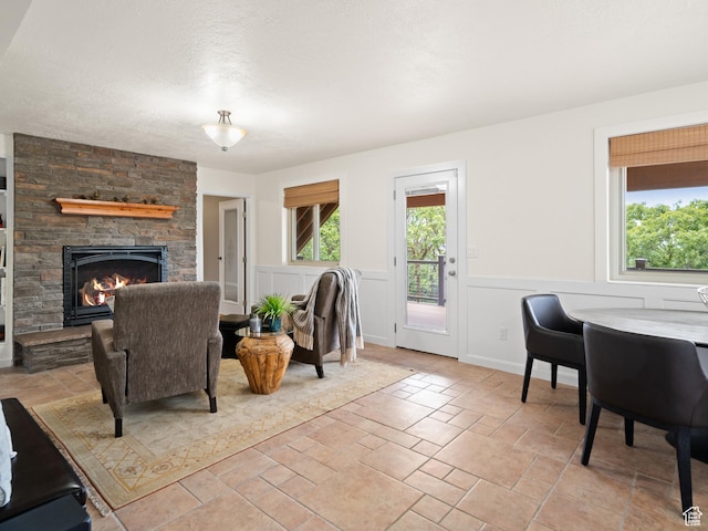 4253 S Spring Rd E, Ogden, UT 84403 - living room featuring a fireplace, wainscoting, and stone tile flooring