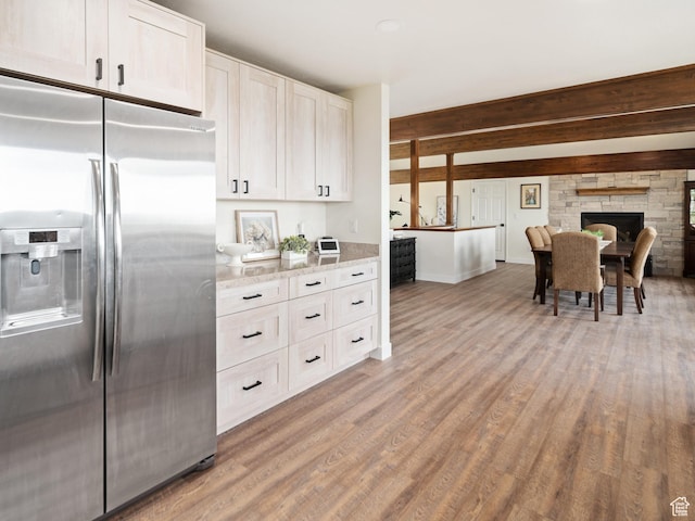 4253 S Spring Rd E, Ogden, UT 84403 - kitchen with stainless steel fridge with ice dispenser, light wood-style floors, light stone countertops, baseboards, and white cabinetry
