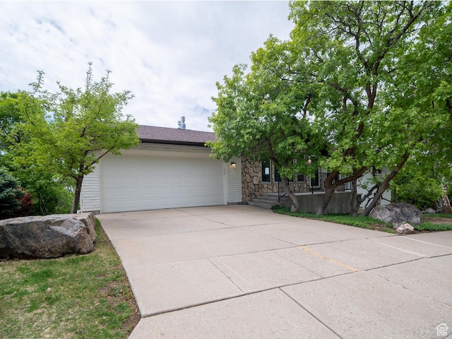 4253 S Spring Rd E, Ogden, UT 84403 - obstructed view of property featuring concrete driveway, a garage, and stone siding