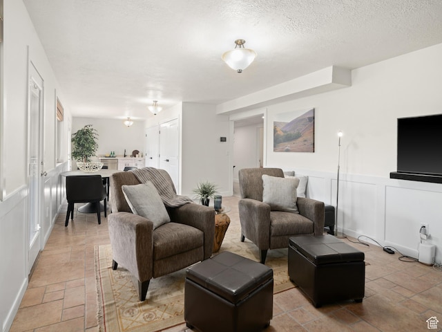 4253 S Spring Rd E, Ogden, UT 84403 - living room featuring stone tile floors, wainscoting, and a decorative wall
