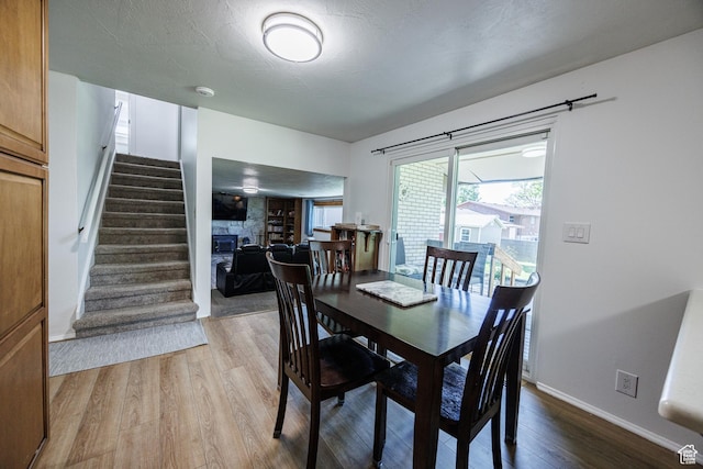 1070 E 120 S, Orem, UT 84097 - dining room featuring stairs, wood finished floors, a glass covered fireplace, and baseboards