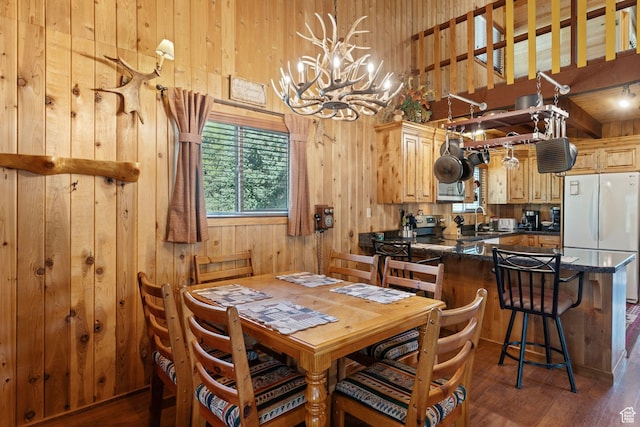 5399 E Targhee Dr E, Oakley, UT 84055 - dining area featuring wood walls, a chandelier, dark wood finished floors, and a high ceiling