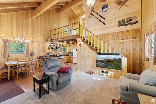 5399 E Targhee Dr E, Oakley, UT 84055 - living area with high vaulted ceiling, wood walls, a chandelier, stairs, and a ceiling fan