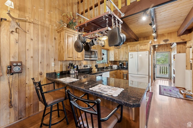 5399 E Targhee Dr E, Oakley, UT 84055 - kitchen featuring appliances with stainless steel finishes, wood walls, hardwood / wood-style flooring, rail lighting, and a sink