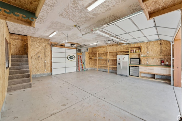 5399 E Targhee Dr E, Oakley, UT 84055 - garage with white fridge with ice dispenser and a garage door opener