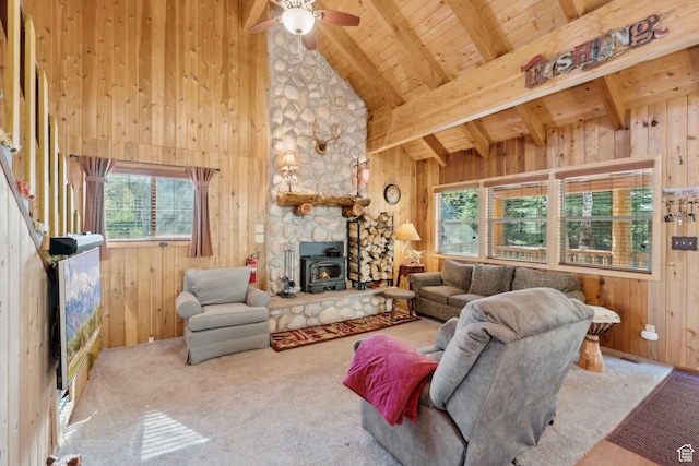 5399 E Targhee Dr E, Oakley, UT 84055 - carpeted living room featuring plenty of natural light, wooden ceiling with exposed beams, a wood stove, wood walls, and ceiling fan
