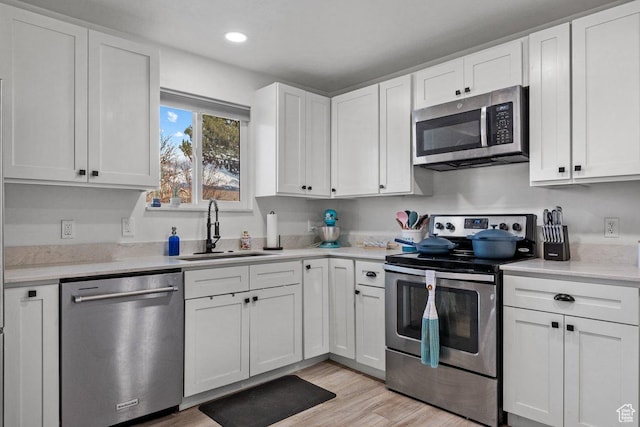 5586 W 10130 N, Highland, UT 84003 - kitchen with stainless steel appliances, a sink, white cabinets, light countertops, and recessed lighting