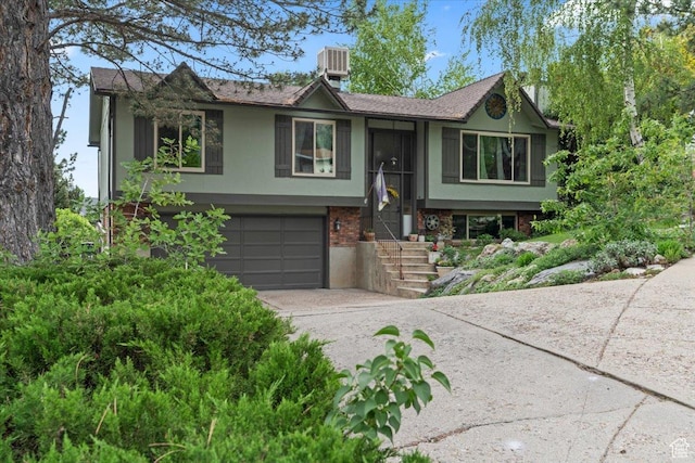 3275 N 250 E, North Ogden, UT 84414 - split foyer home with driveway, a garage, brick siding, cooling unit, and stucco siding