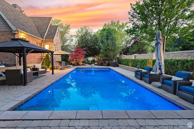 963 E Old English Rd, Draper, UT 84020 - pool at dusk with an outdoor hangout area, a patio, a gazebo, and a fenced backyard