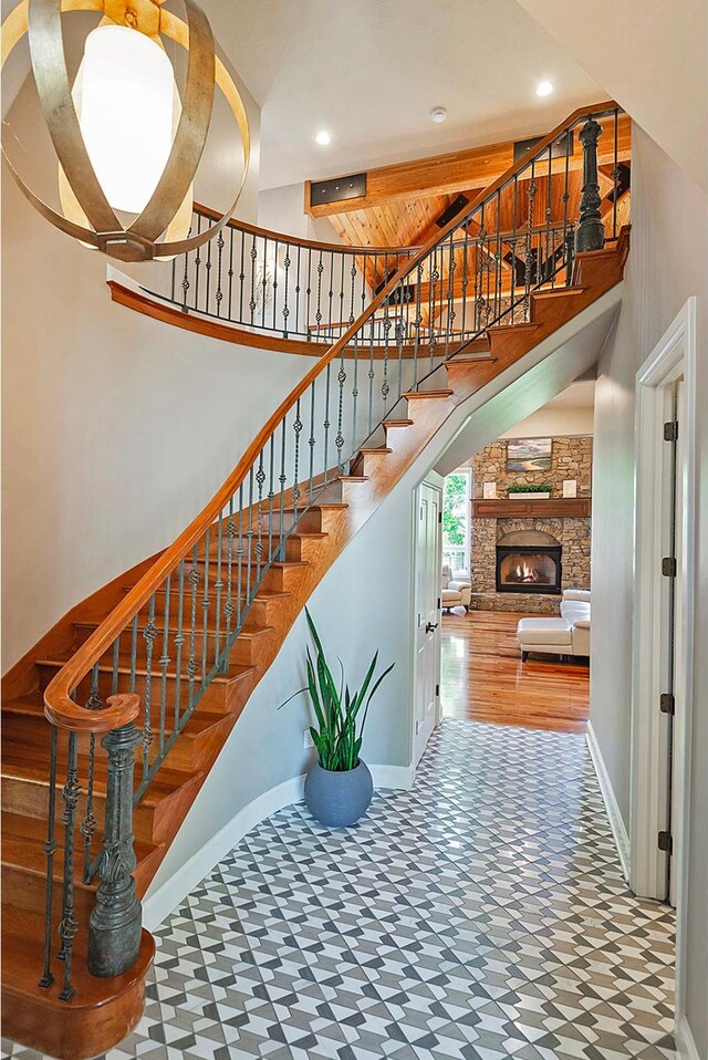 963 E Old English Rd, Draper, UT 84020 - staircase with tile patterned floors, baseboards, a towering ceiling, recessed lighting, and a stone fireplace