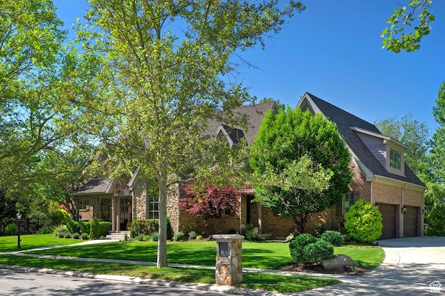 963 E Old English Rd, Draper, UT 84020 - view of property hidden behind natural elements featuring concrete driveway, an attached garage, brick siding, and a front lawn