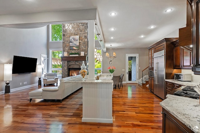 963 E Old English Rd, Draper, UT 84020 - living area with wood finished floors, a stone fireplace, baseboards, recessed lighting, and stairs